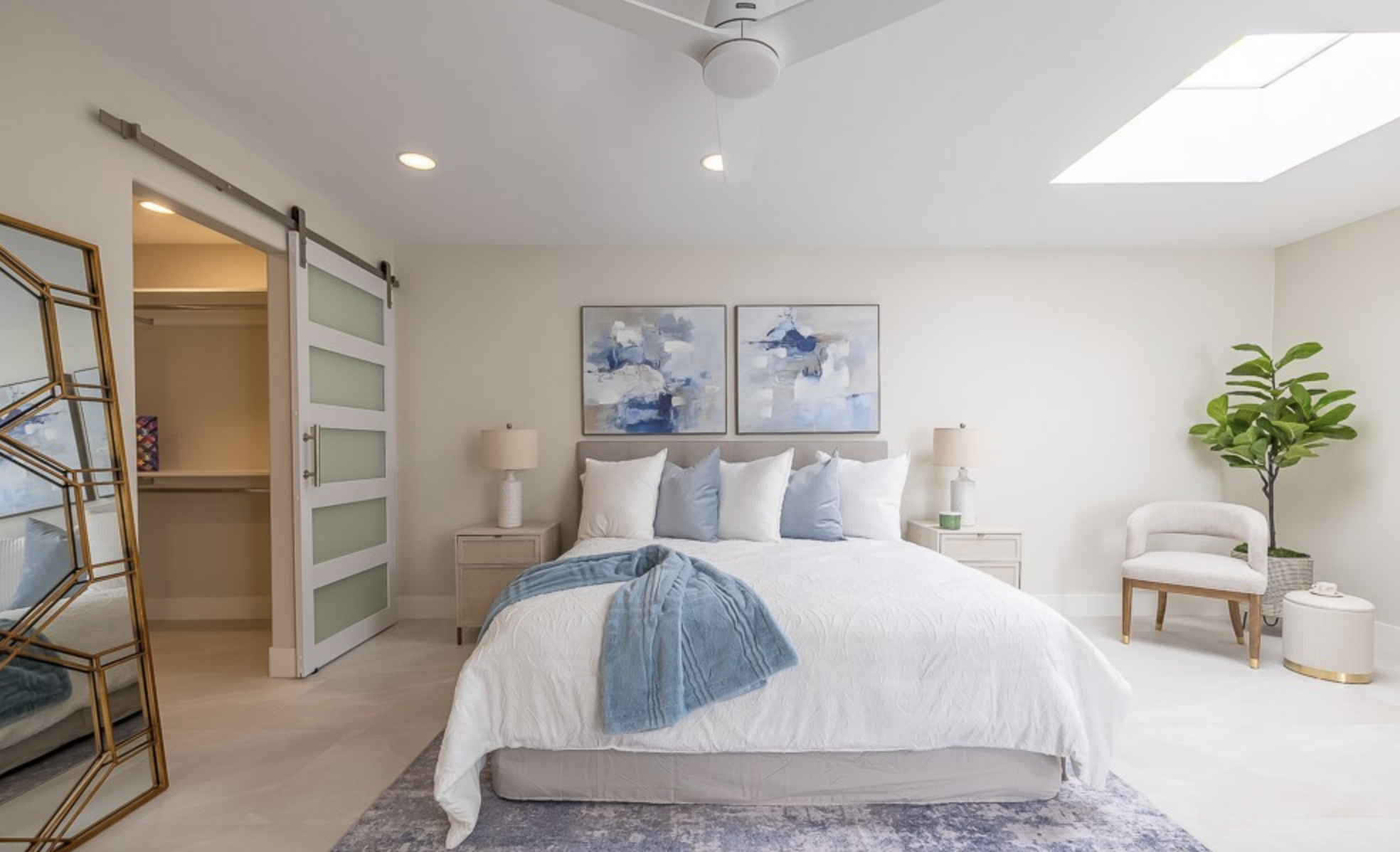 Bright remodeled primary bedroom suite with skylight and custom sliding door